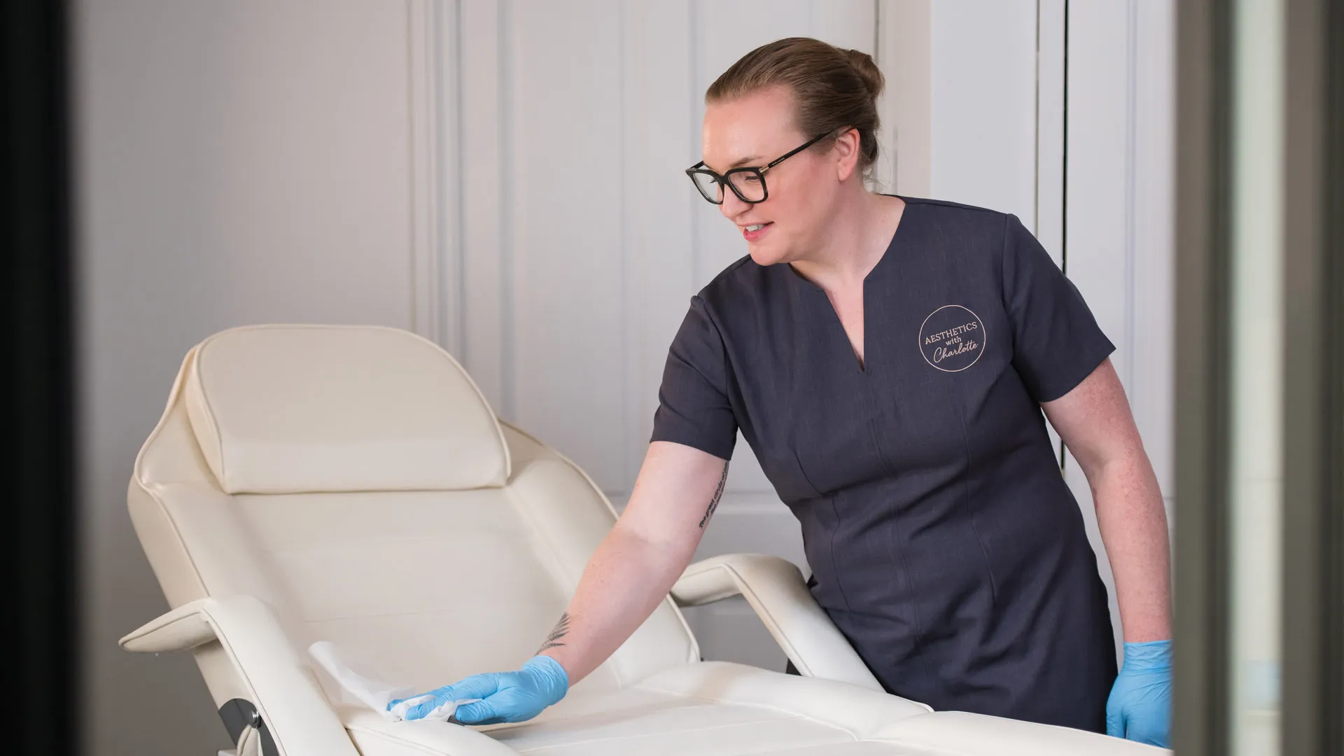Charlotte in her embroidered tunic, preparing the treatment couch in her Bournemouth clinic